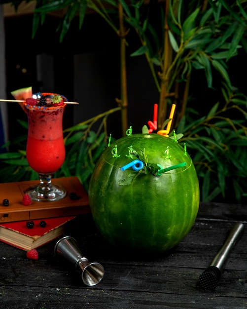 Free photo watermelon cocktail in watermelon skin with straws