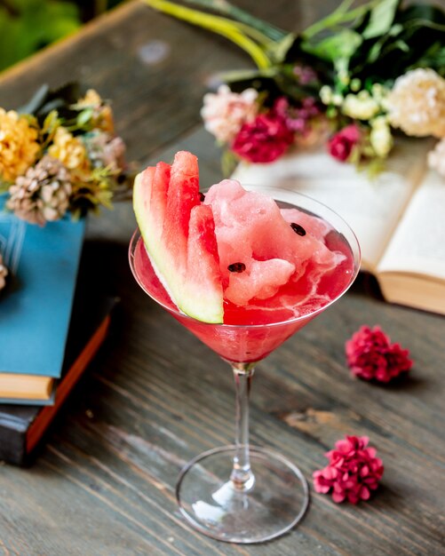 Watermelon cocktail with fruit and flowers.