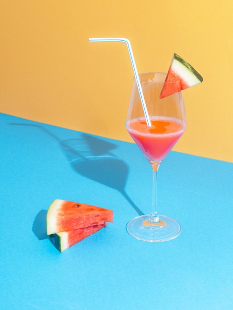 Foto gratuita cocktail di anguria con fette contro il blu pastello e baige ba