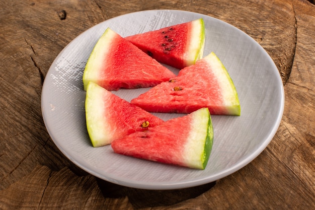 Free photo watermelon slices fresh and mellow pieces inside plate on brown