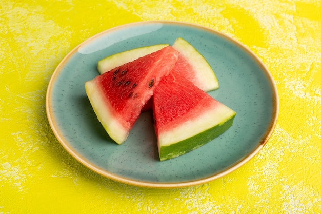 Free photo watermelon slices inside green plate on yellow