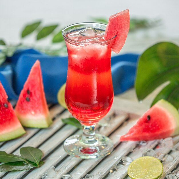 Watermelon smoothie with ice cubes in a glass.