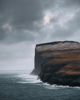 Waves crashing against the cliff in the north of faroe island