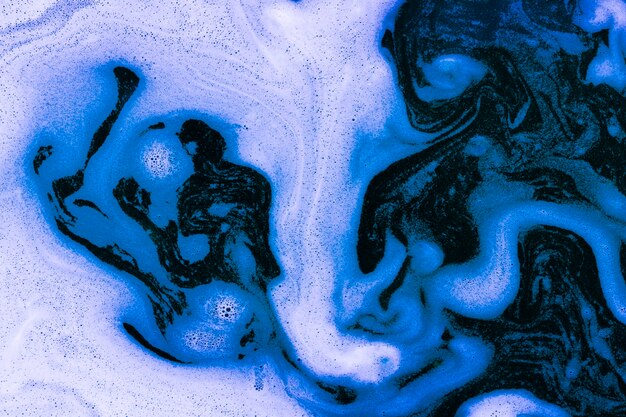 Waves of foam on blue liquid