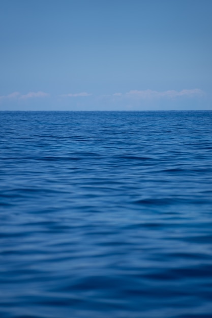 澄んだ青い空の下の海の波