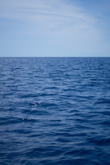 澄んだ青い空の下の海の波