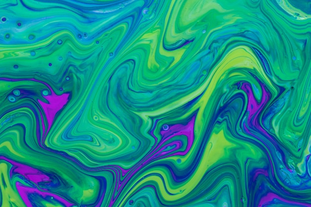 Free photo wavy green and violet fluid acrylic pour painting