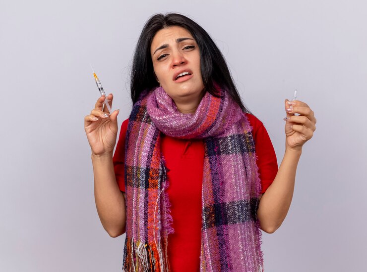 मुफ़्त फोटो weak and scared young caucasian ill girl wearing scarf holding syringe and ampoule  isolated on white wall with copy space