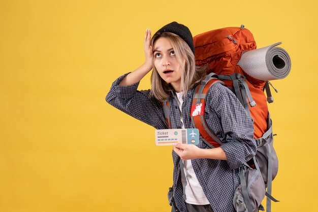 weary traveler woman with backpack holding her head