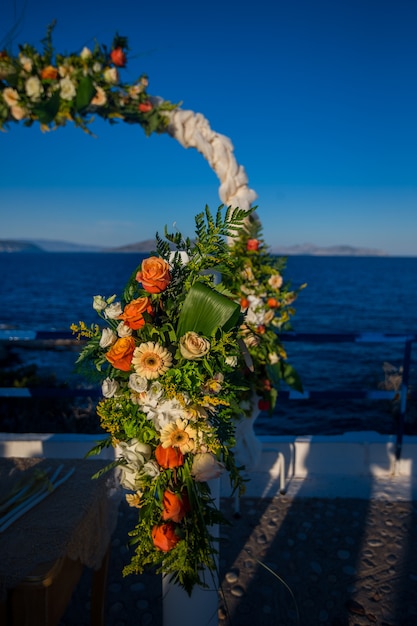 緑とオレンジの花で飾られた結婚式の祭壇