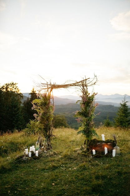 Бесплатное фото Свадебный алтарь из зеленых веток и деревянных палочек