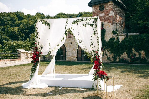 正方形のカーテン製の結婚式の祭壇は、裏庭に立っています