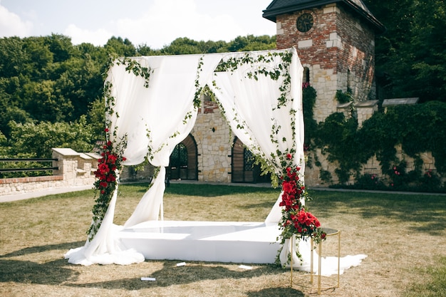 Wedding altar made of square curtains stands on the backyard