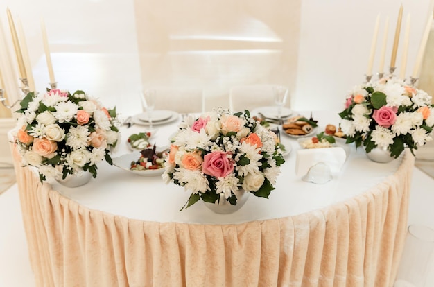 Свадебный банкет. цветы и еда на праздничном столе. пустой праздничный стол в ресторане. Premium Фотографии