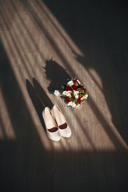 The wedding bouquet stands near shoes