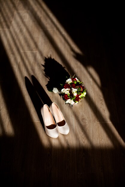 The wedding bouquet stands near shoes