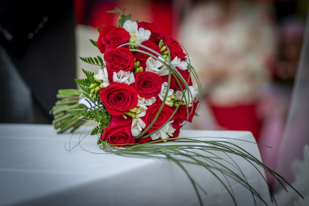테이블에 빨간 장미와 웨딩 부케