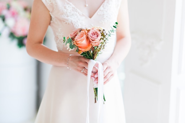 Wedding bride holding pink flower bouquet. 