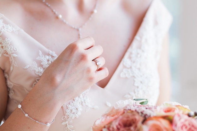 Wedding bride holding pink flower bouquet. 