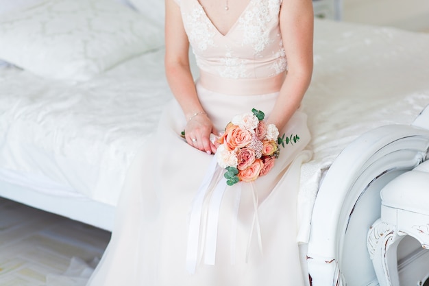 Wedding bride holding pink flower bouquet. 