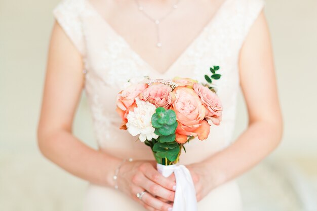Wedding bride holding pink flower bouquet. 