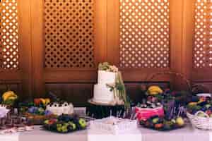 Free photo wedding cake and sweets stand served on block on the buffet