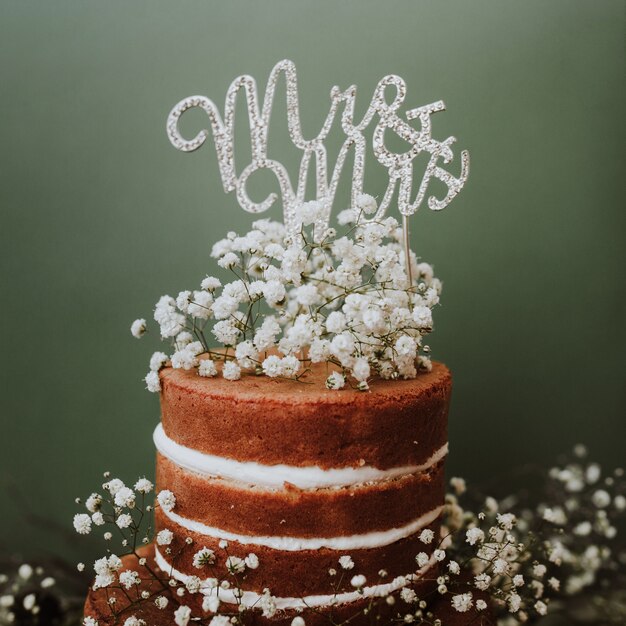 Свадебный торт с украшением метелькой и топпер Мистер и Миссис на зеленом фоне