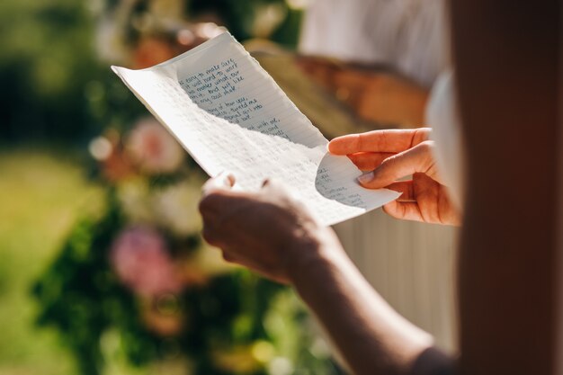 結婚式。花嫁は彼の宣誓で紙を握る