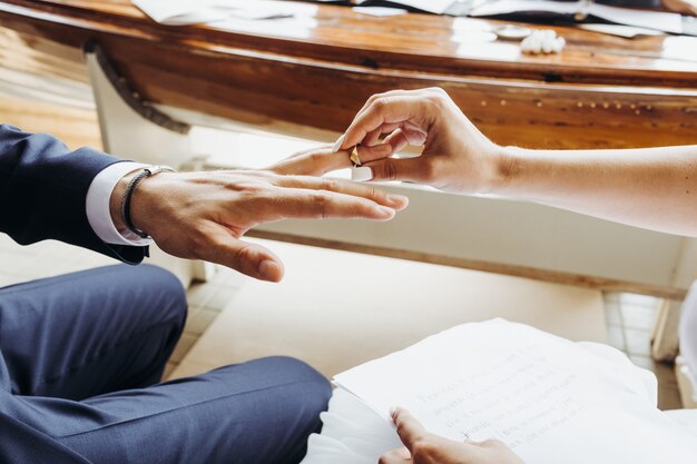 Wedding ceremony. Bride's puts ring on groom's finger