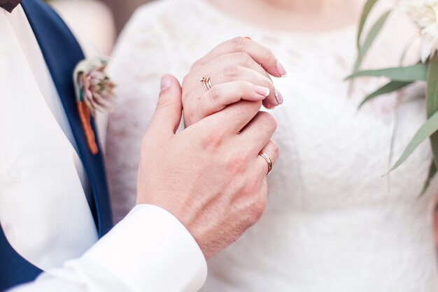 Wedding couple holding hands.