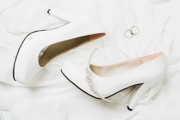 Wedding crown and rings with wedding high heels on white scarf