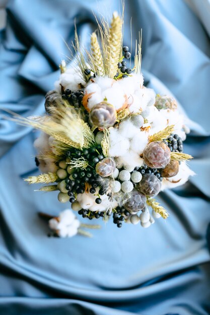 Свадебные украшения цветы вид сверху на синем фоне ткани