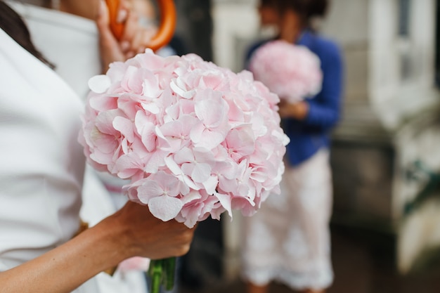 Wedding details. Bride holds tender pink bouquet in her arms. No face