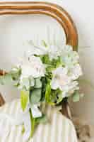 Free photo wedding jasminum auriculatum flower bouquet on wooden chair