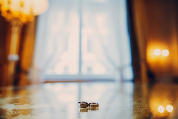 L'anello nuziale della sposa e dello sposo giacciono sulla lampada nella stanza