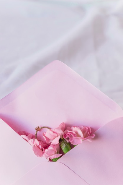 Wedding ring in envelope with bright flowers