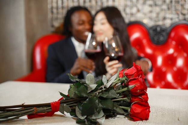 Wedding ring on the girl's finger. Bouquet of red roses. Engagement gift.