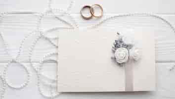 Бесплатное фото Обручальные кольца и колокольчики с пригласительным конвертом