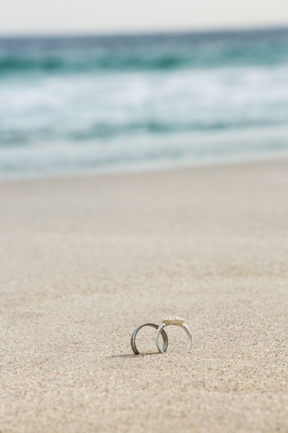 Foto gratuita anelli di nozze su sabbia