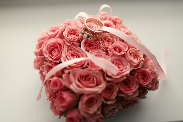 The wedding rings stand under bouquet