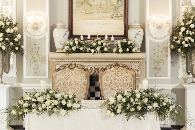 A wedding table setting with floral decorations and candles with hanging light bulbs