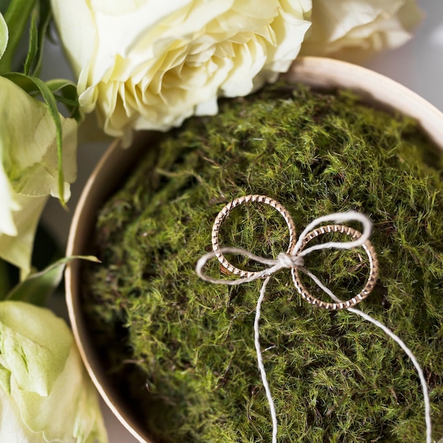 Weeding rings tied with strings on moss put with roses