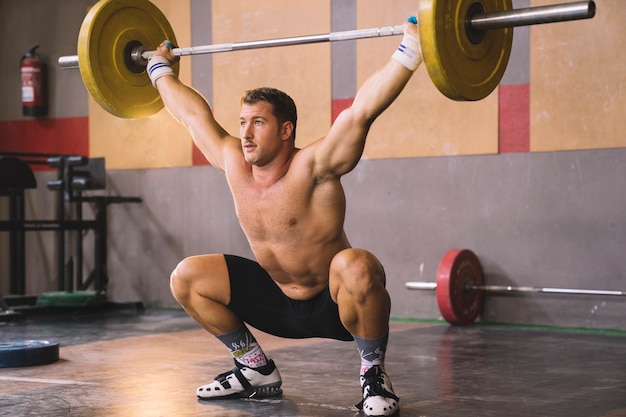 Foto gratuita concetto di sollevamento del peso con il barbell di sollevamento dell'uomo