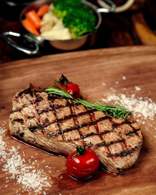 Well-done piece of steak on a wooden board