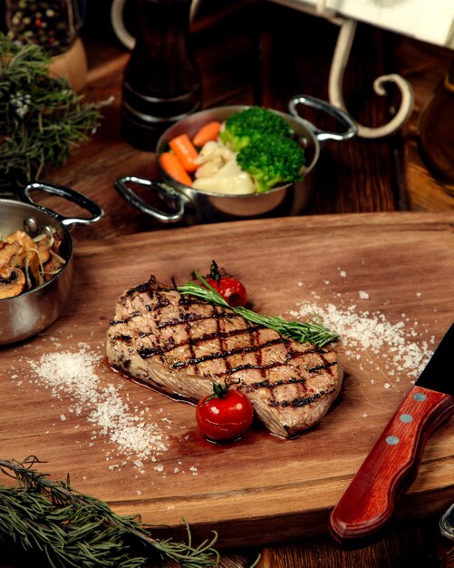 Well-done steak tomatoes on a wooden board