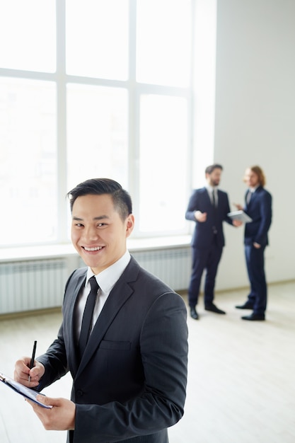 Free Photo well-dressed businessman holding a clipboard