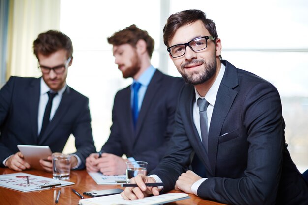 Well-dressed executive with co-workers background