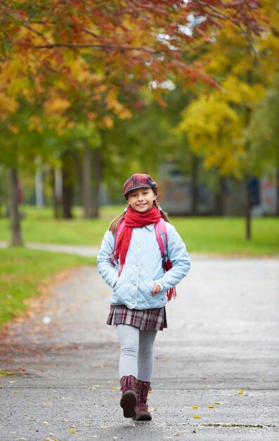 公園の中を歩いてきちんとした服装の女の子