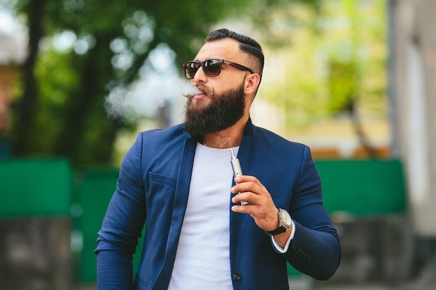 Well-dressed man smoking electronic cigarette