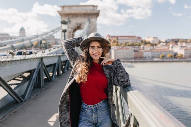 Well-dressed woman in glasses walking down the bridge